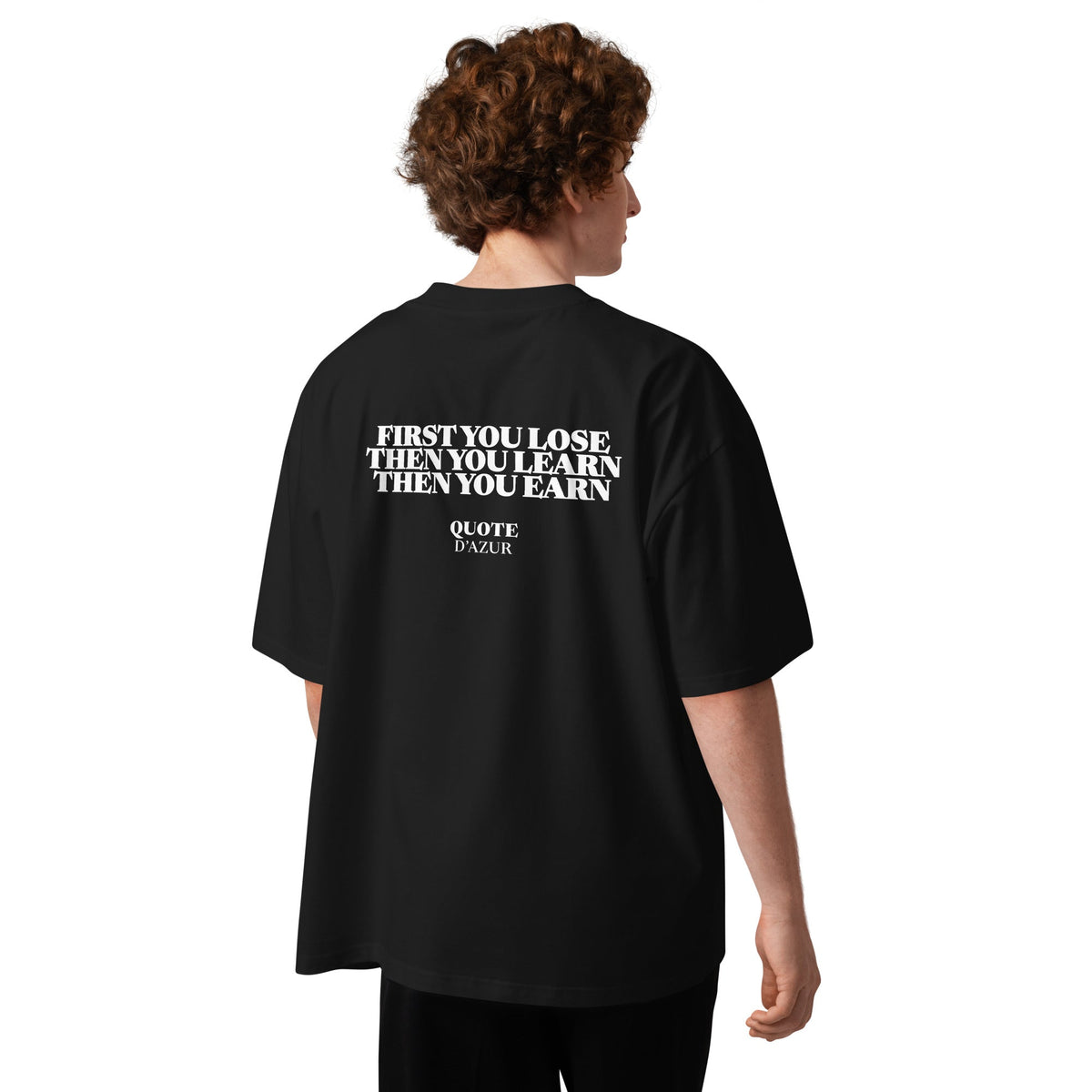 First You Lose, Then You Learn, Then You Earn – Oversized T-Shirt in Black, back view on a male model.